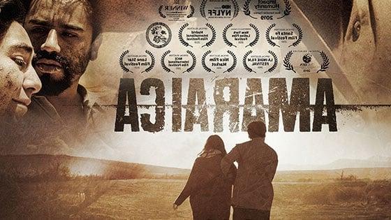 The movie poster for Amaraica. A man and a woman walk across a deserted field with their backs facing the camera.