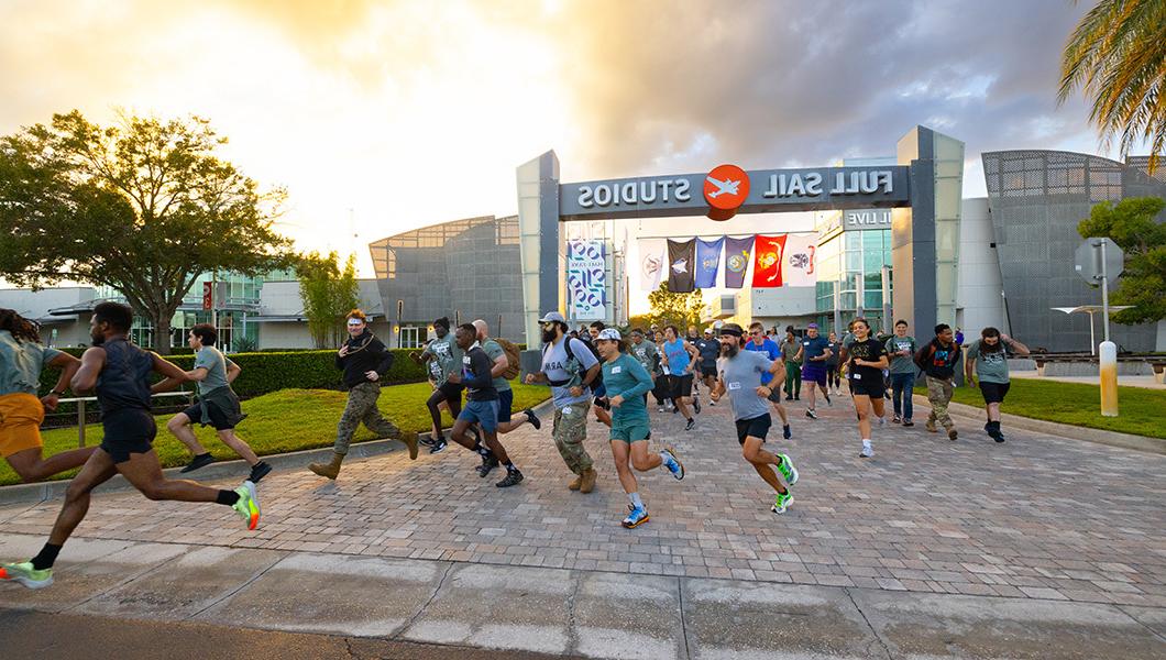 Dozens of runners race under the Full Sail Studios sign and into the parking lot.