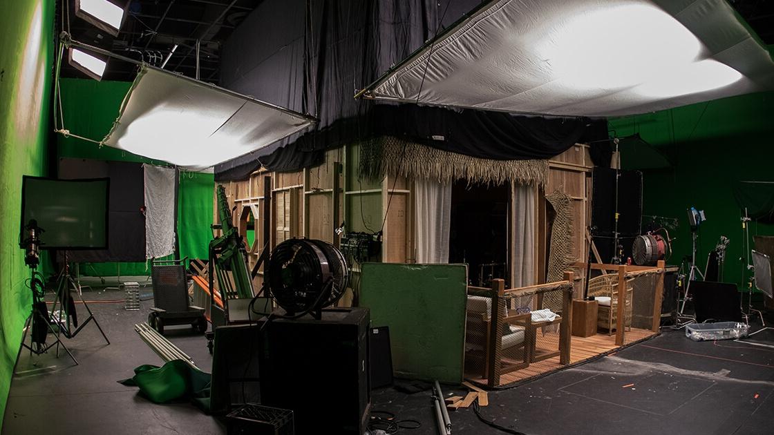 A sound stage with a wooden set resembling a seaside villa.